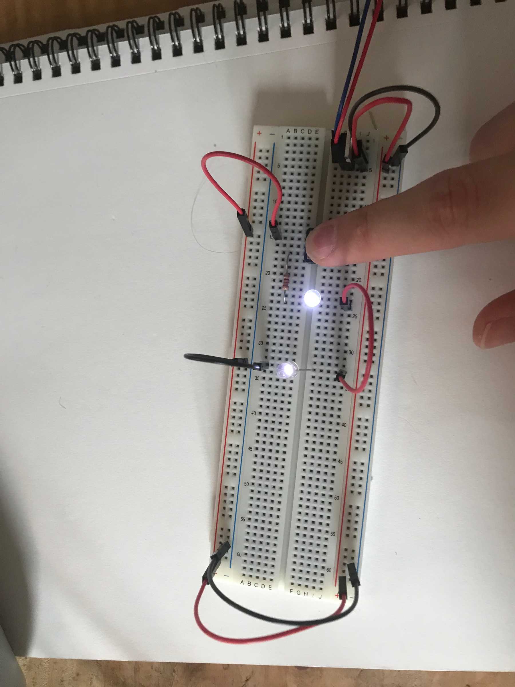 Pressing the button causes both LEDs to illuminate faintly